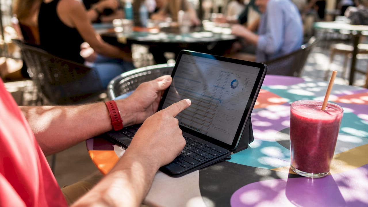 Hands reviewing SEO spreadsheet on tablet