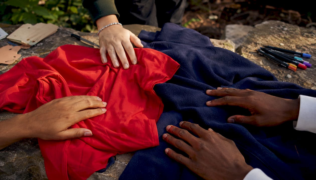 Hands feeling t-shirt and hoodie fabrics close-up