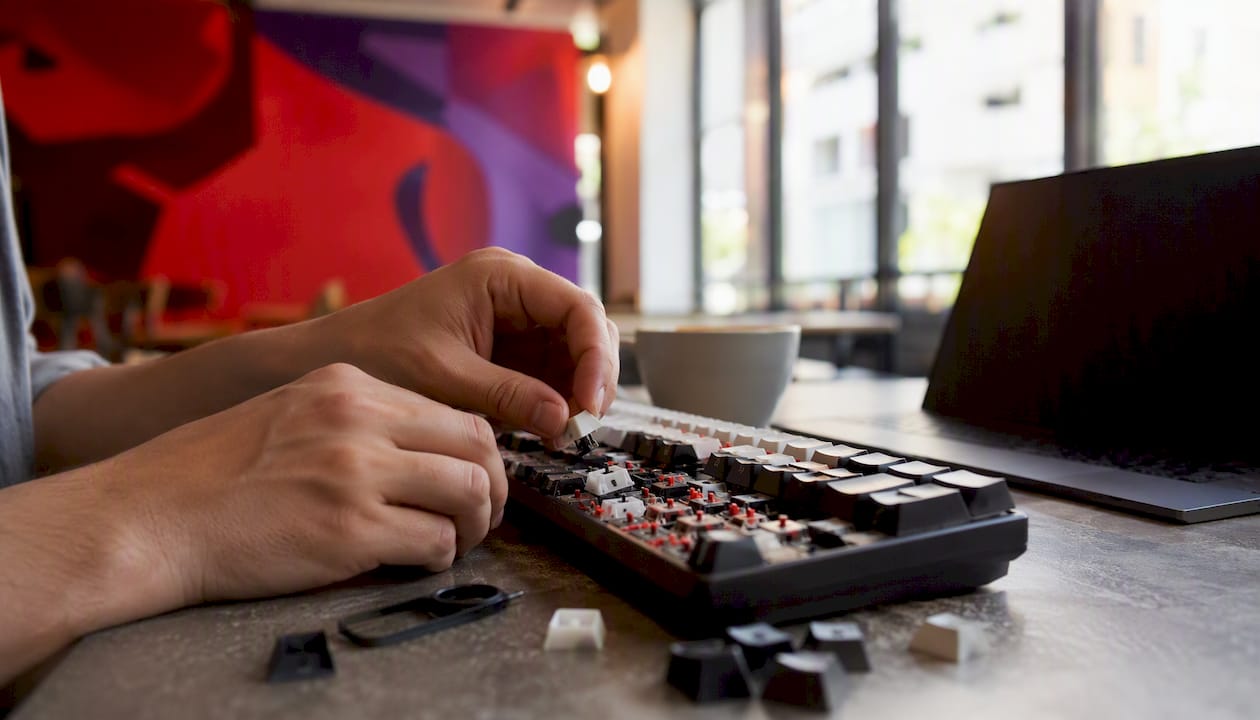 Hands swapping keyboard keys close-up
