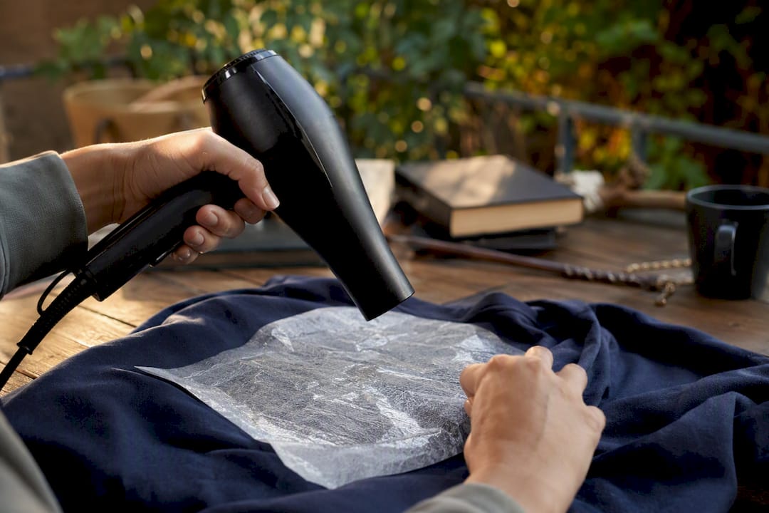 Close-up of fabric being heated with hair dryer