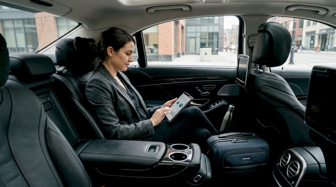 Executive reviewing tablet in luxury car