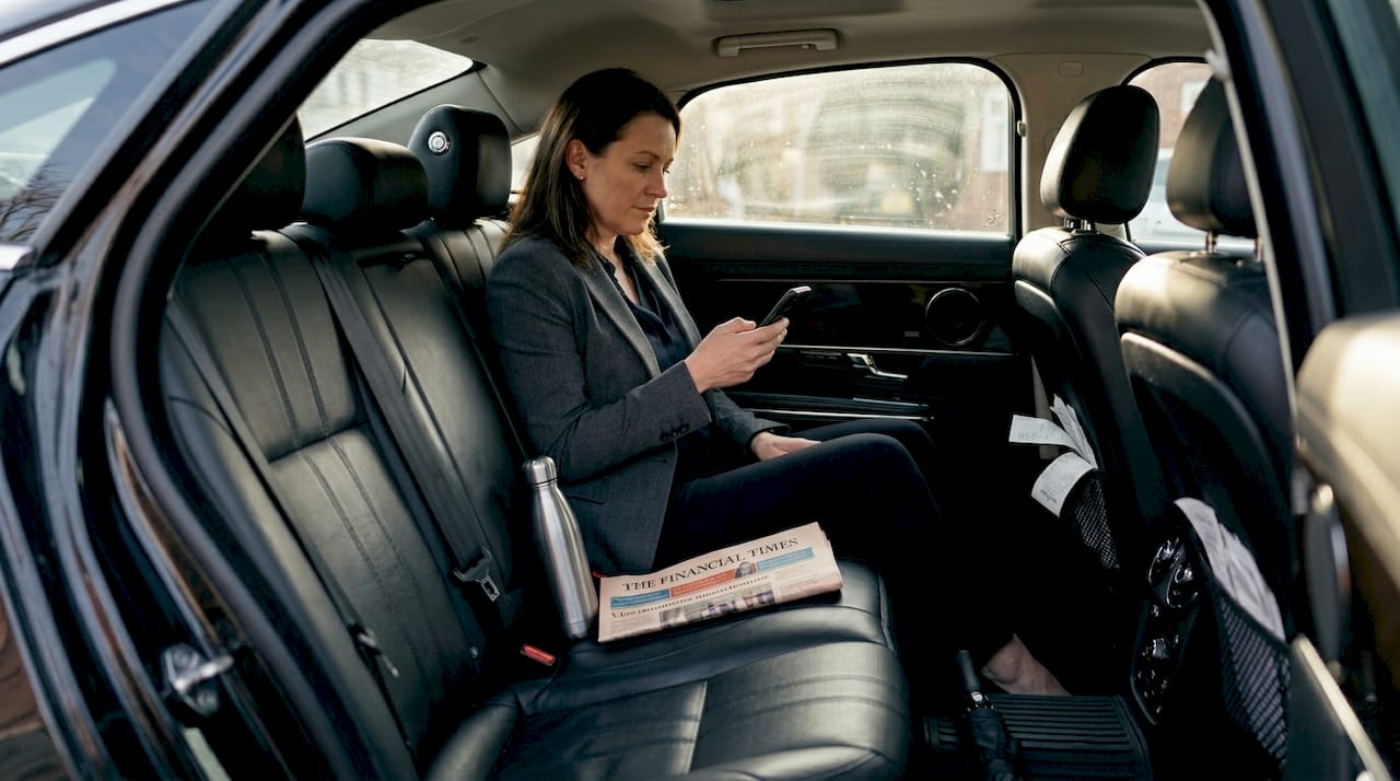 Businesswoman in spotless executive car interior