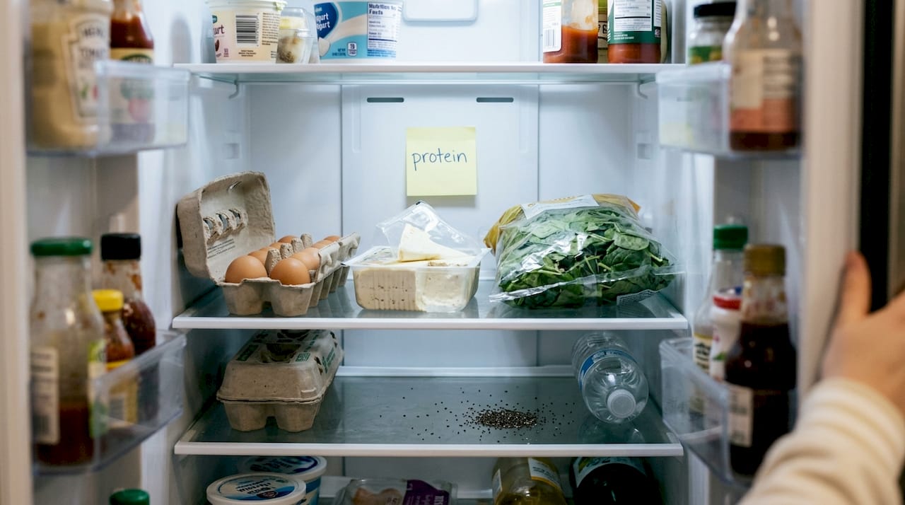 Open fridge with various protein foods inside