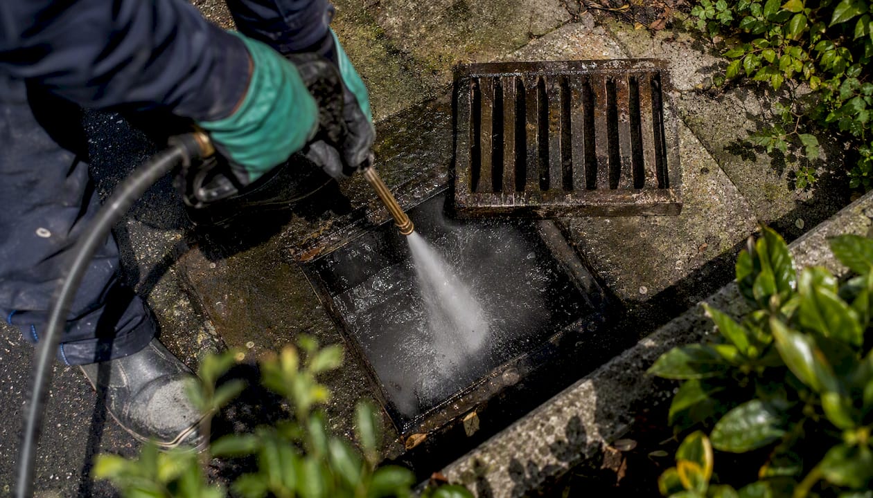 Hands jetting blocked garden drain