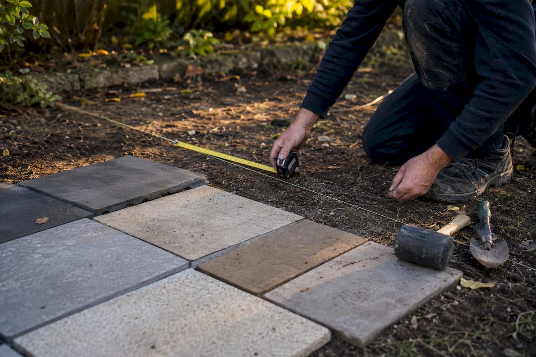 Hands measuring garden area for landscaping quote