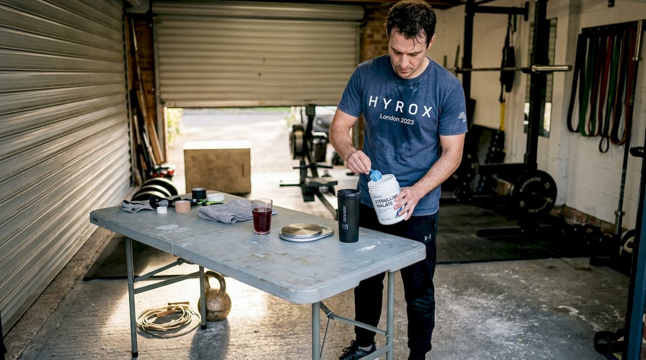 Athlete mixes supplement in home gym