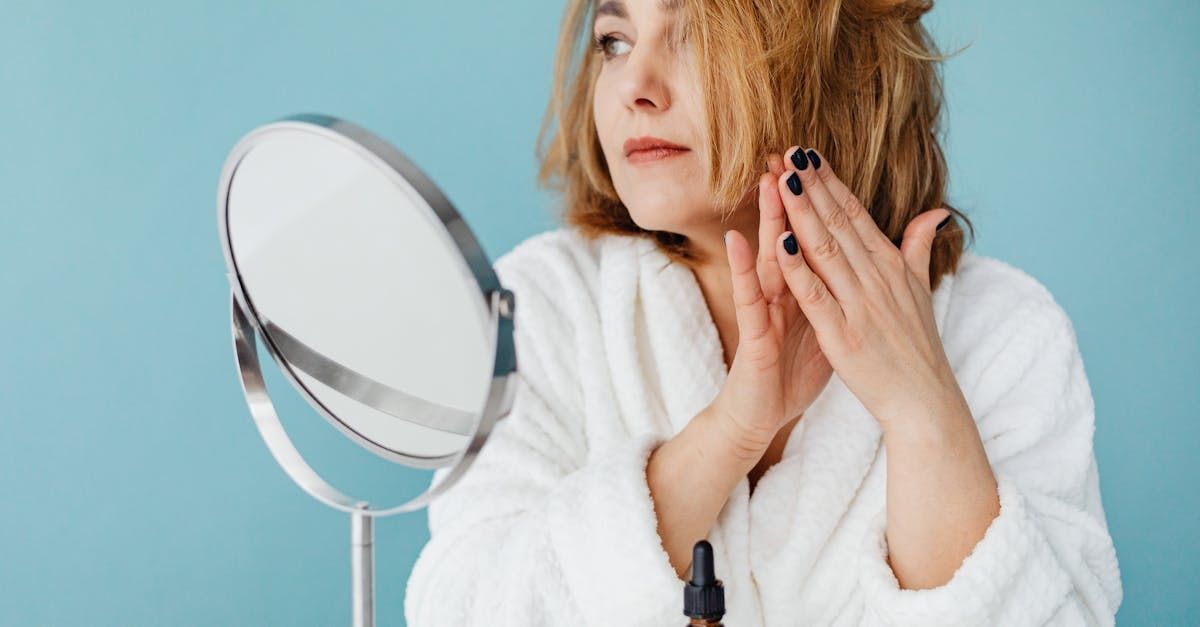 Person applying hair oil to scalp