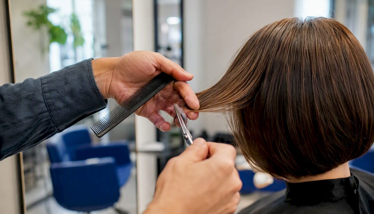 Peluquero dando forma con precisión a un corte bob
