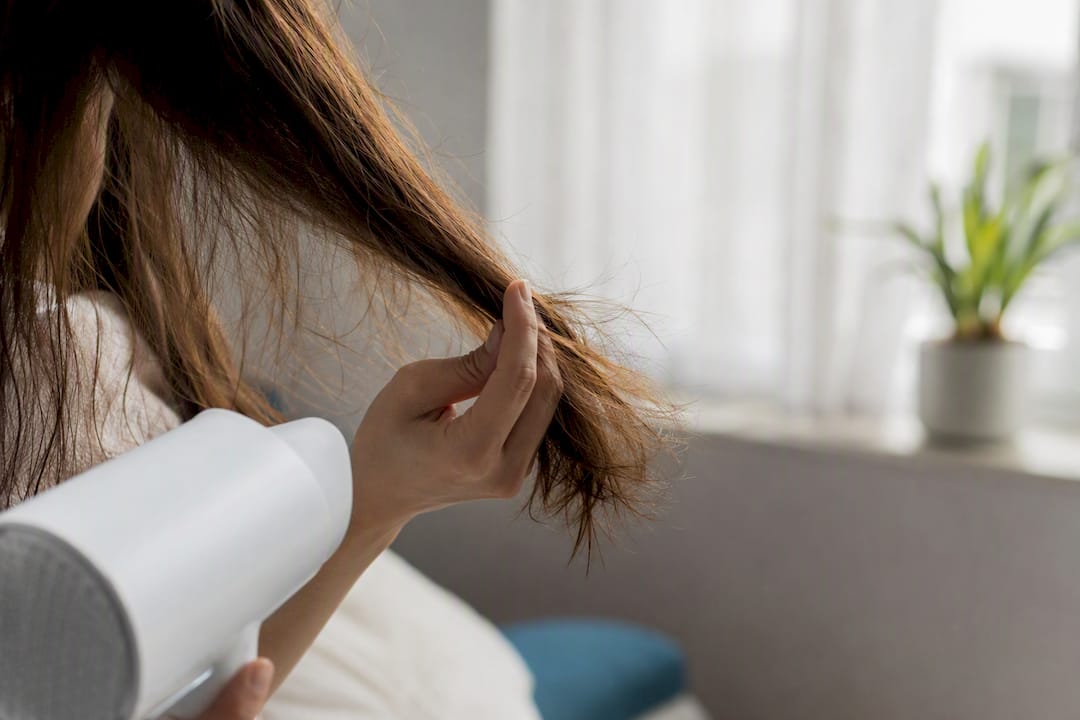 Hand holding damaged dry hair strands