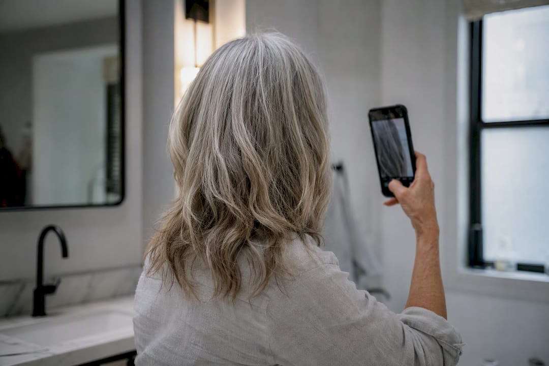 Frau fotografiert ihre Kopfhaut zur Dokumentation des Haarfortschritts