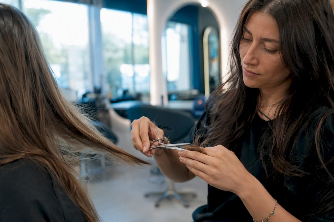 Close-up of hairstylist trimming split ends