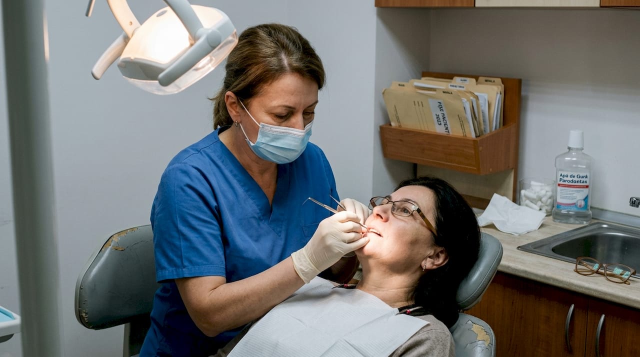 Medicul parodontolog îi verifică sănătatea gingiilor pacientei.