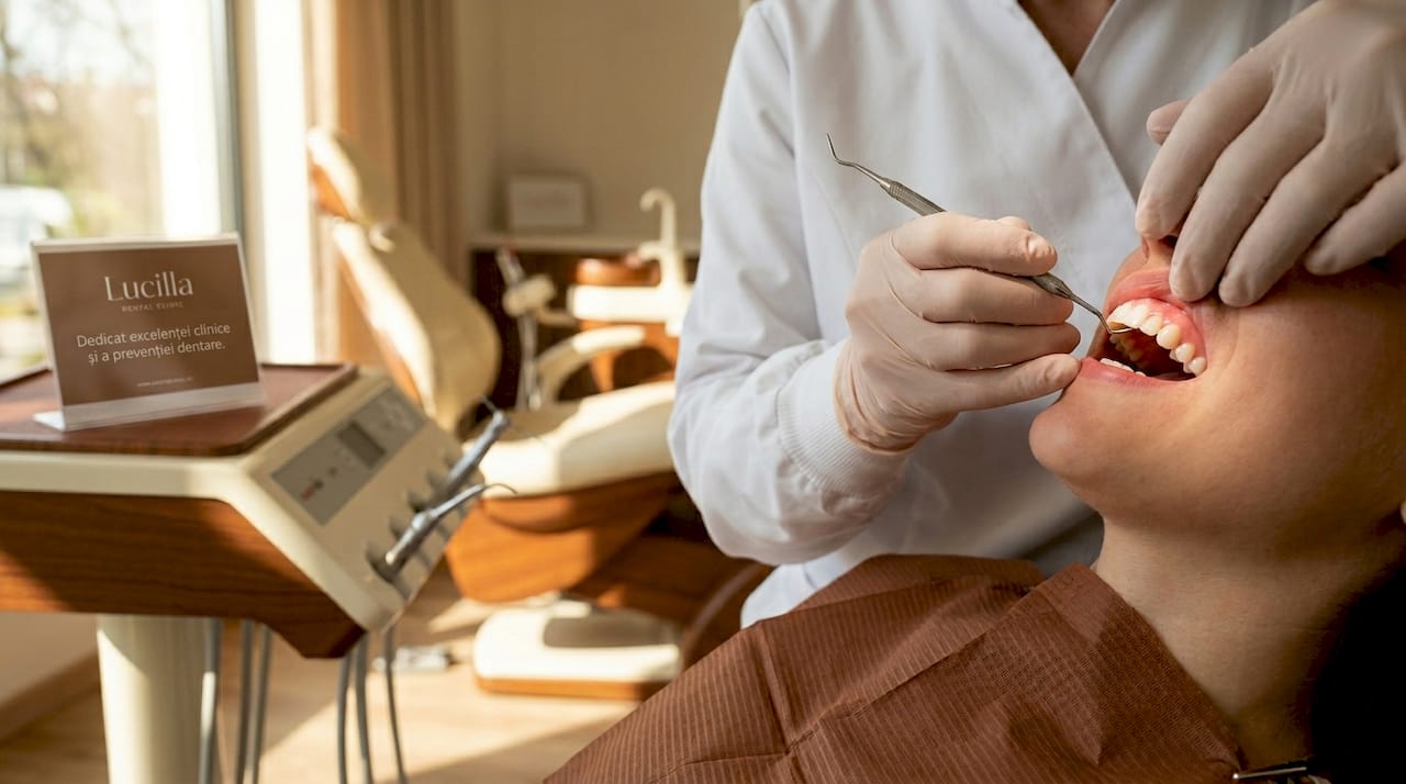 Medic stomatolog care verifică sănătatea gingiilor și a dinților la o consultație de rutină