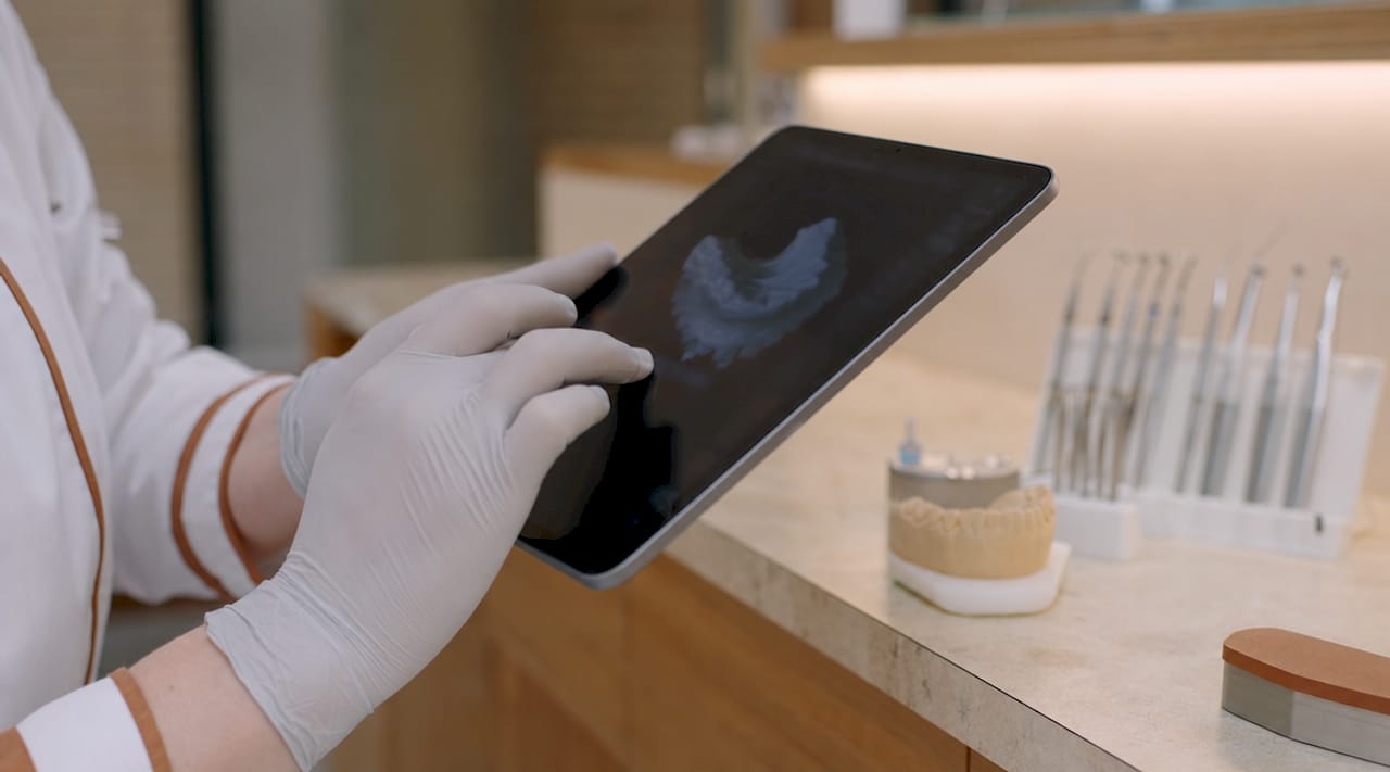 Mâini care ajustează un model 3D digital al dinților
