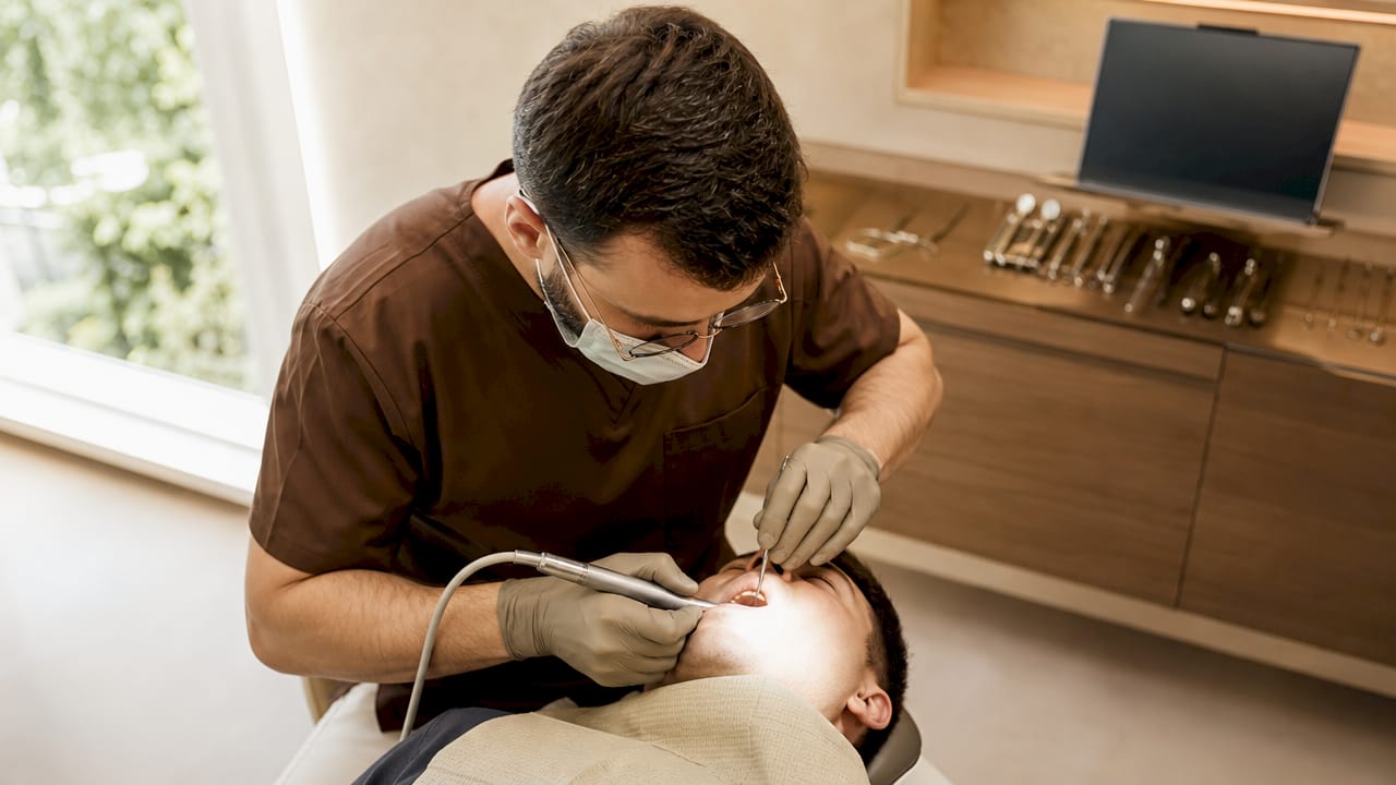 Medicul chirurg oral în timpul intervenției de îndepărtare a unui molar inclus