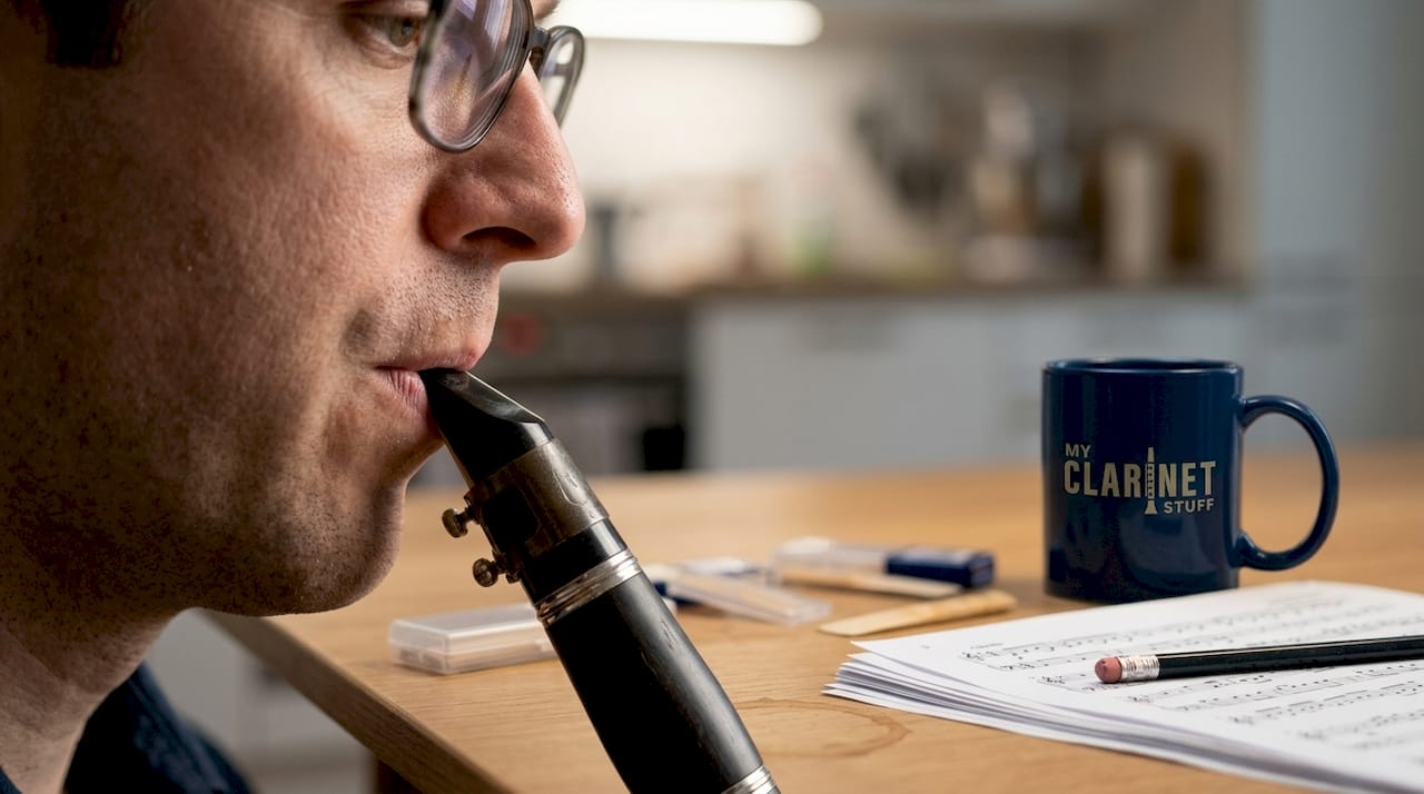 Clarinetist demonstrates proper embouchure at table