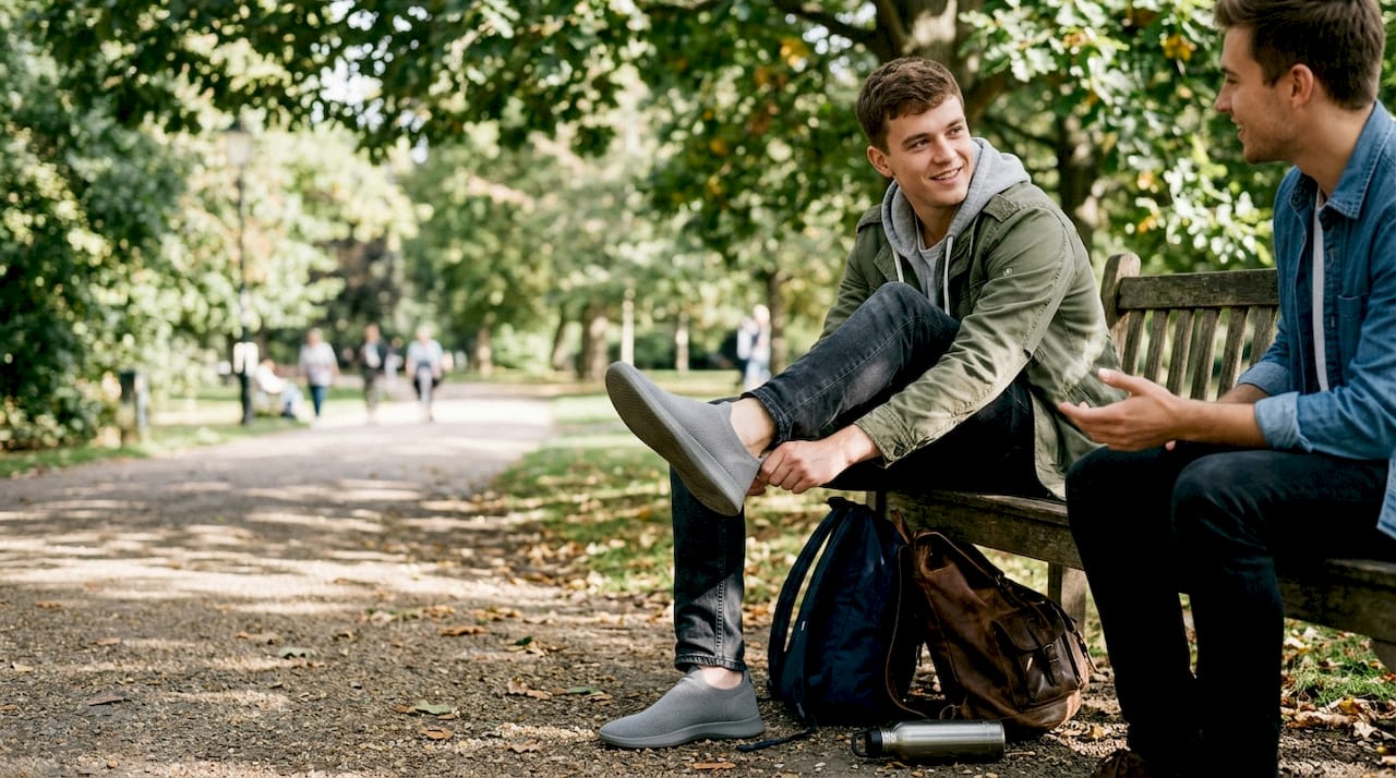 Person putting on seamless sneakers in park