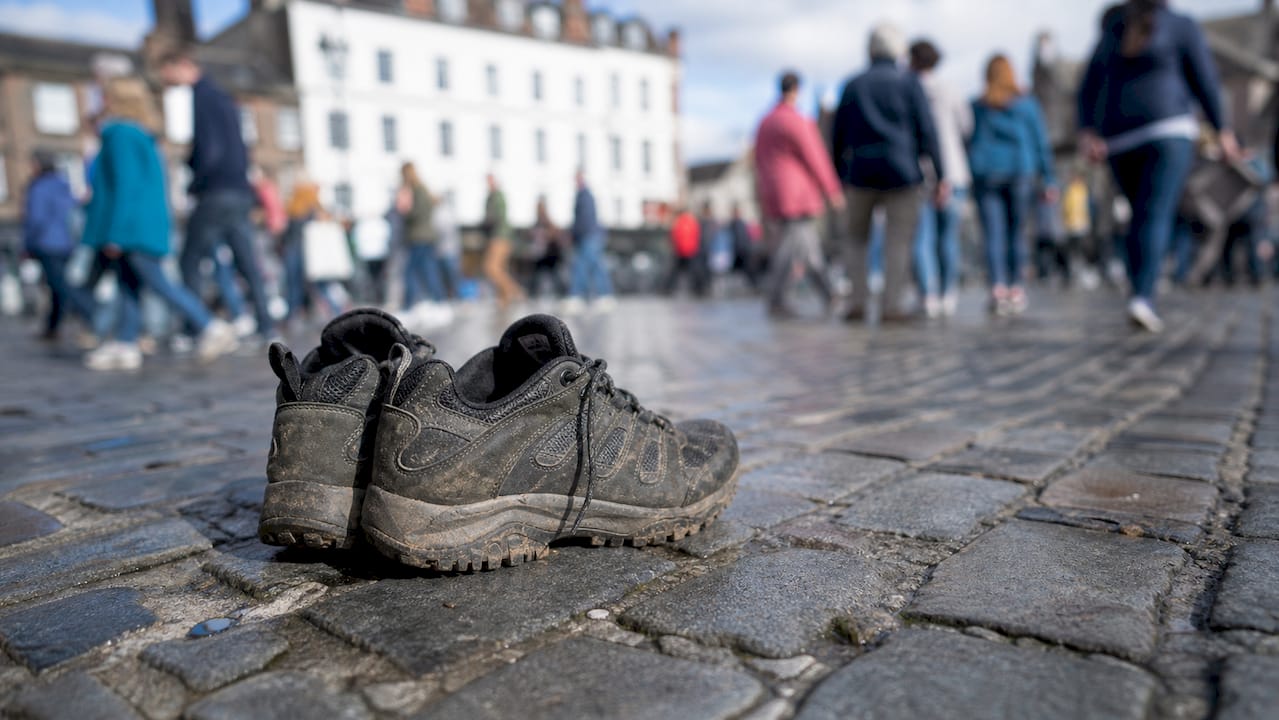 Close-up of walking shoes on wet pavement