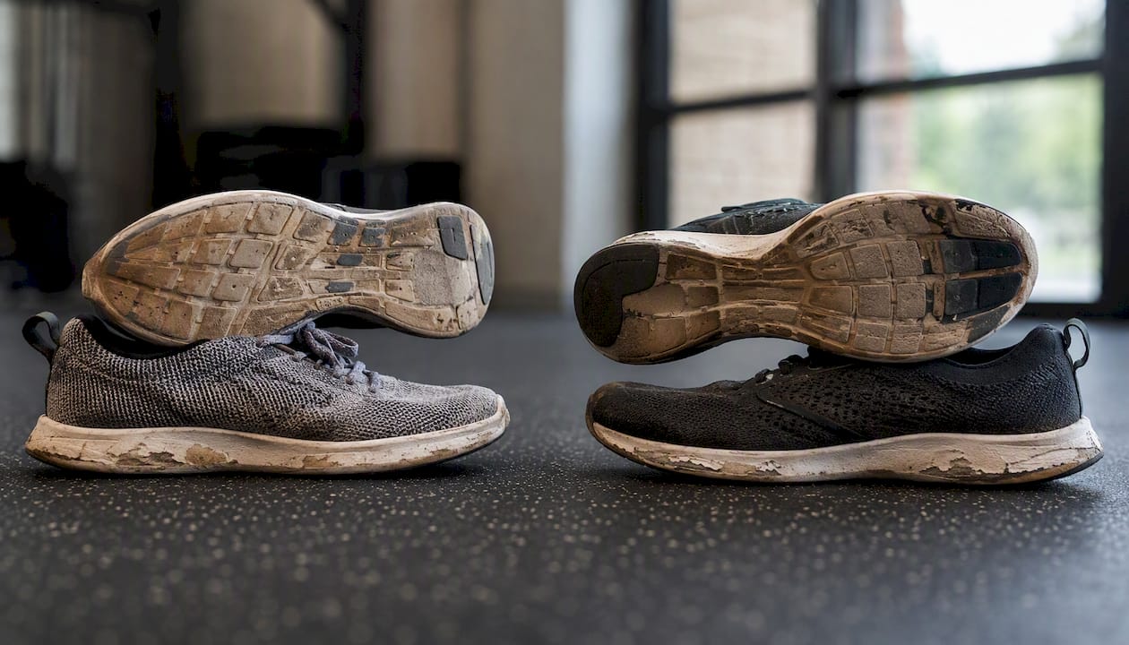 Two pairs of athletic shoes side by side showing wear
