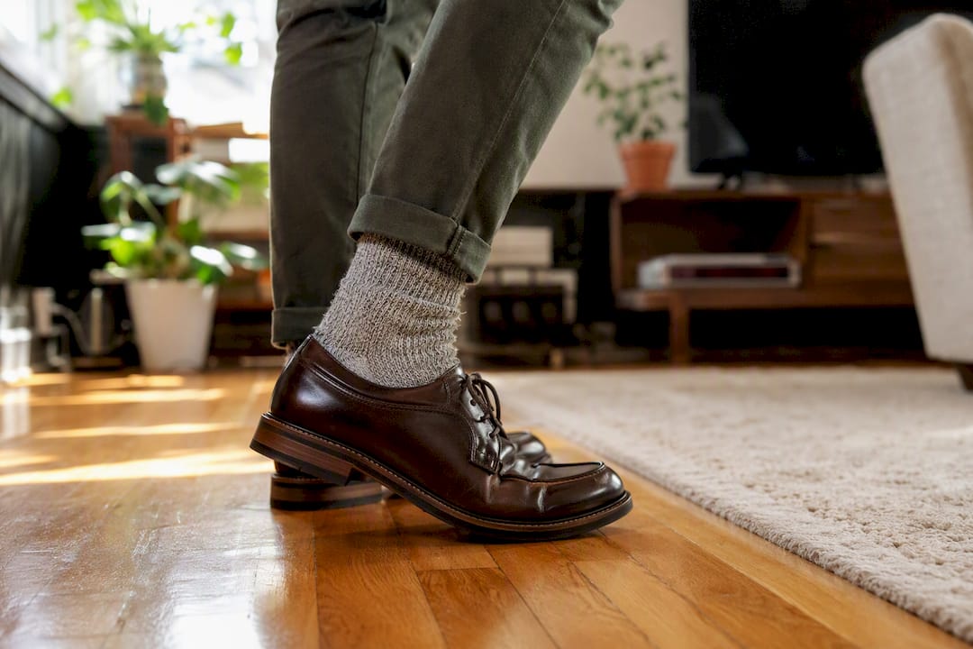 Feet in leather shoes with thick socks indoors