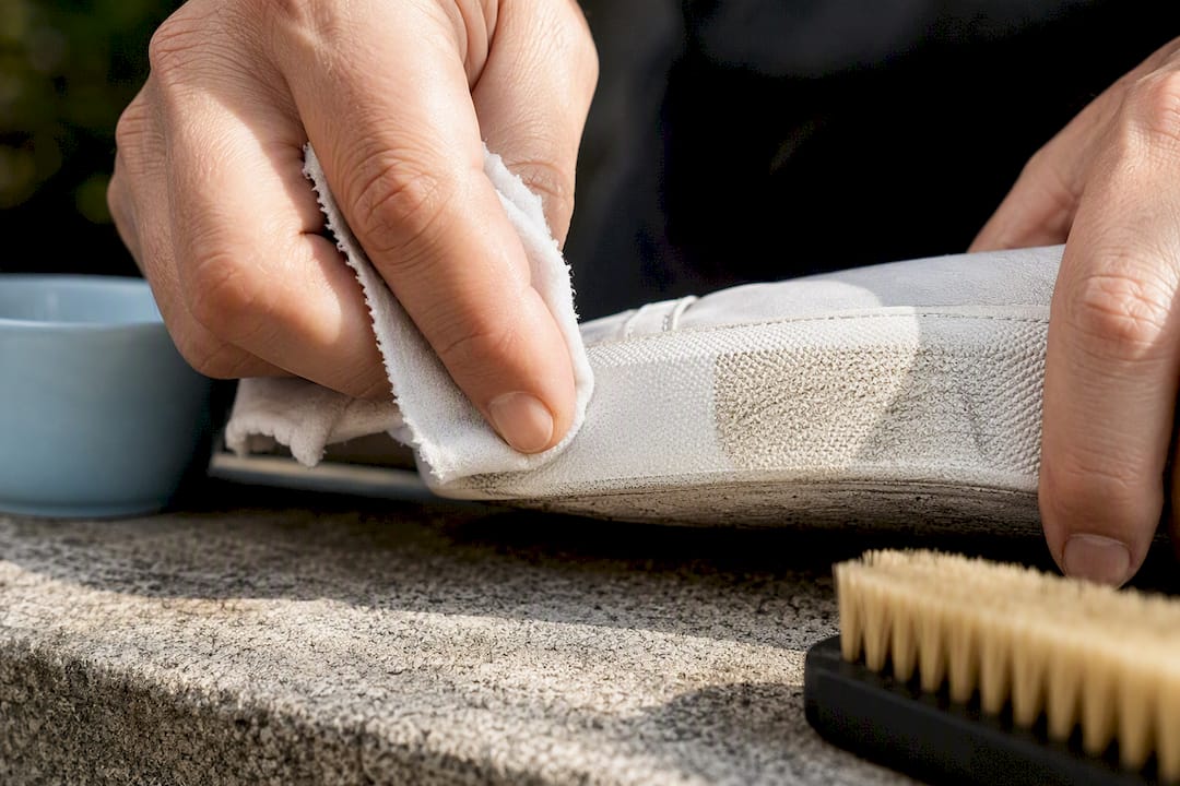 Cloth wiping scuffed white sneaker midsole