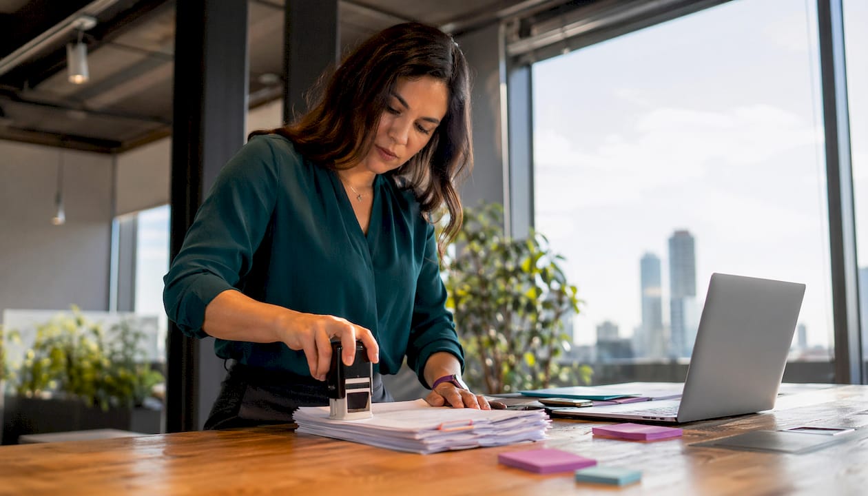 Woman stamping documents in office