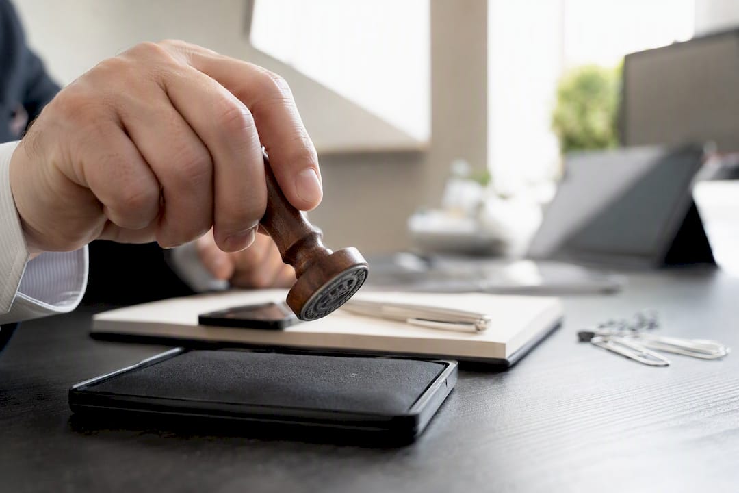Hand pressing rubber notary stamp into ink pad