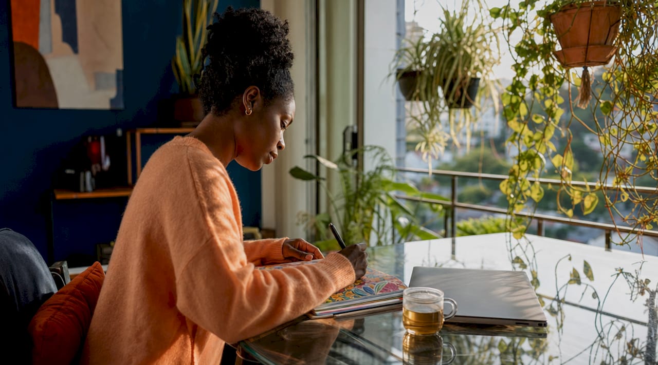 Woman taking notes at home office desk