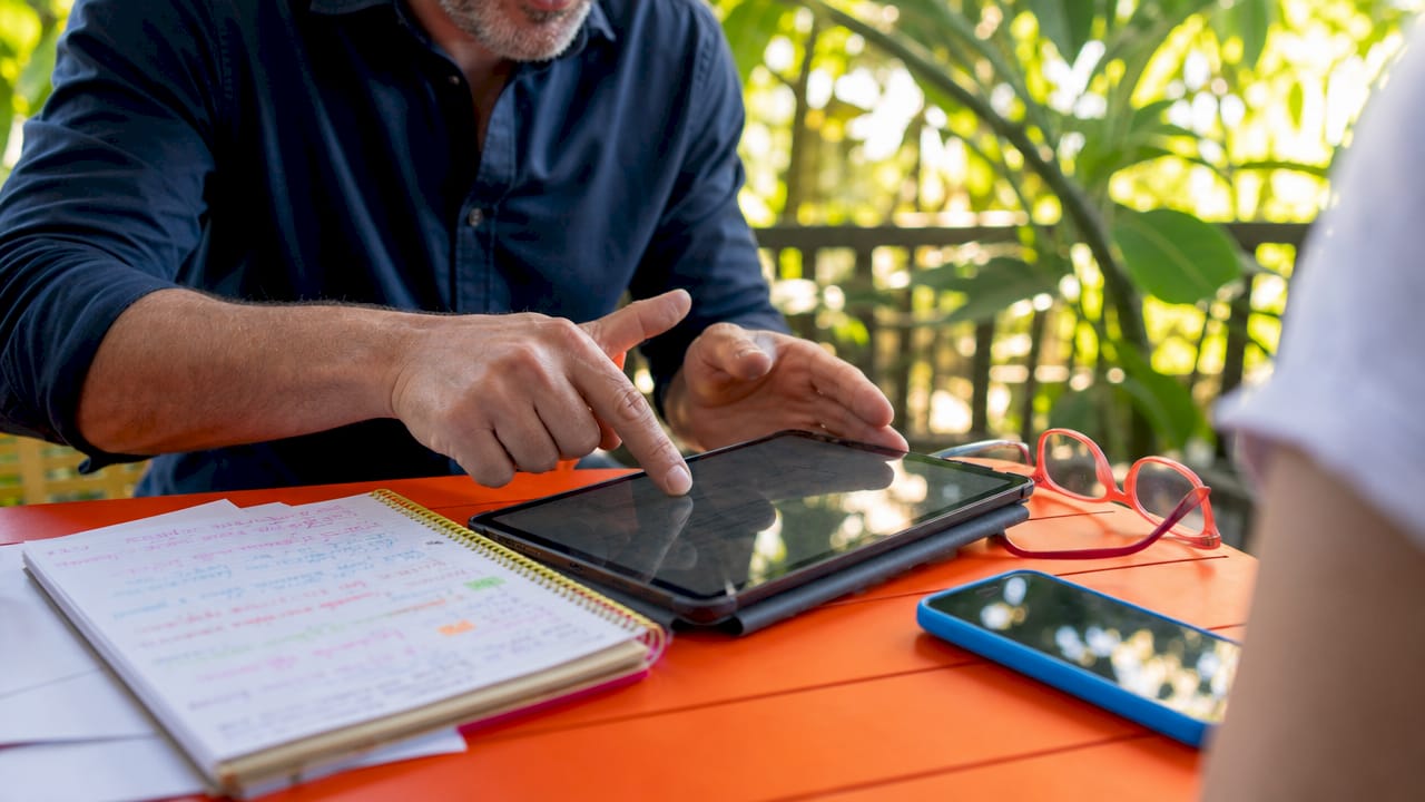Mentor demonstrating skill using tablet close-up