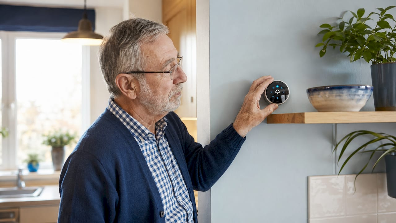 Man adjusting thermostat in UK home