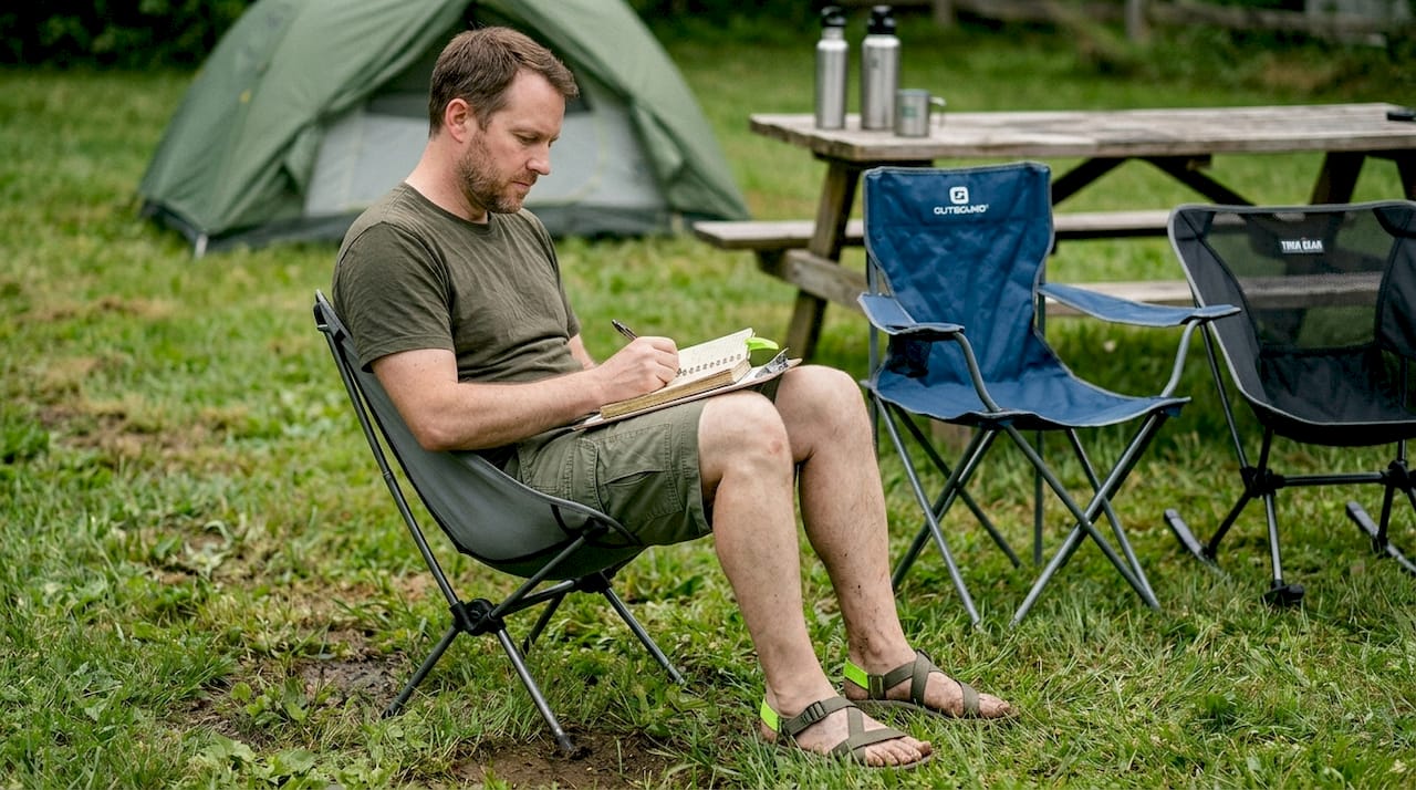 Man testing different folding camp chairs outdoors