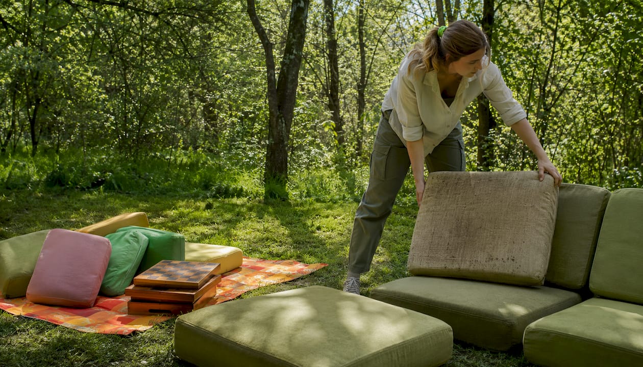 Hands replacing cushion on modular outdoor seat