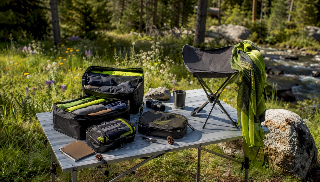Packable camping accessories on wooden table outdoors