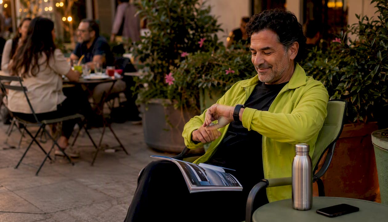 Man seated on foldable seat at city bus stop