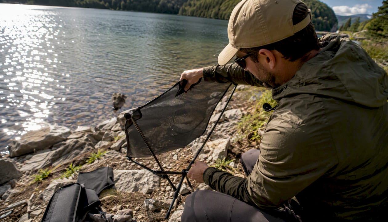 Hiker unfolding packable camp seat outdoors