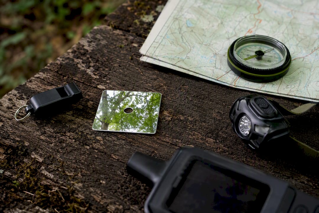 Emergency backpacking gear laid out on stone