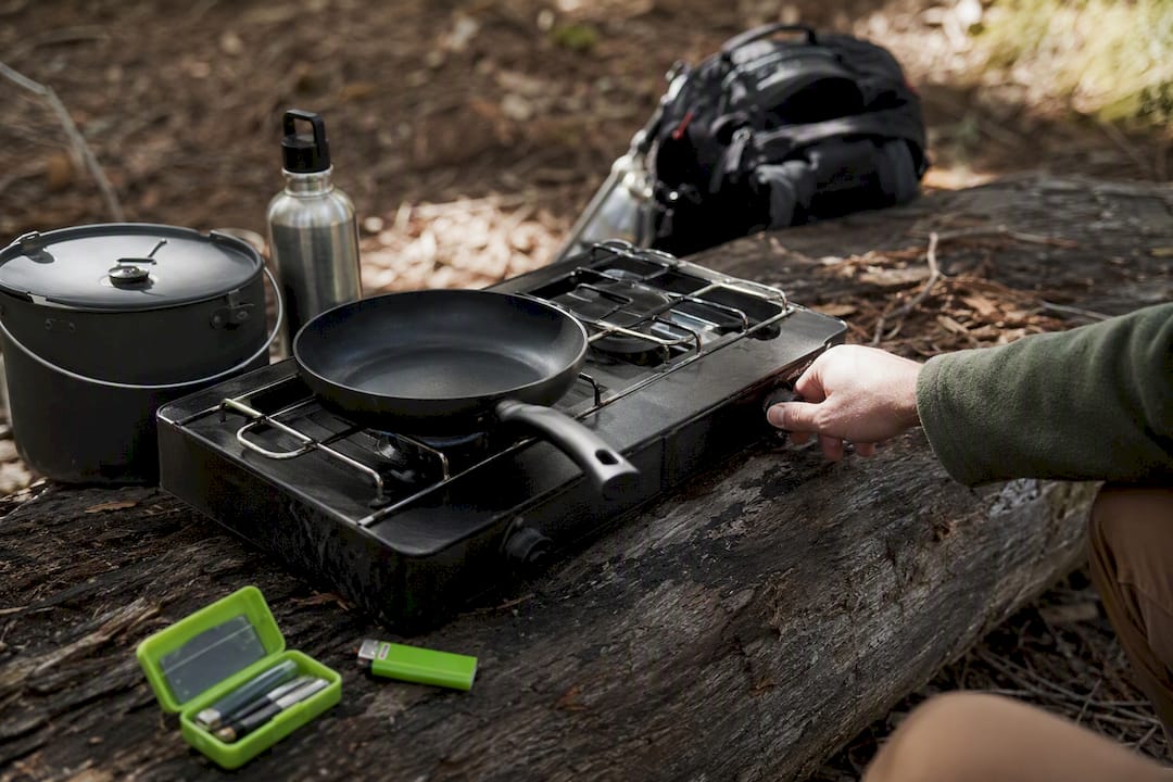 Camp stove and cooking gear on stone
