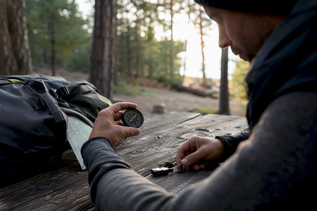 Hands handling navigation and safety gear outdoors