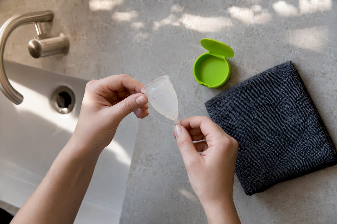 Hands preparing a menstrual cup for camping