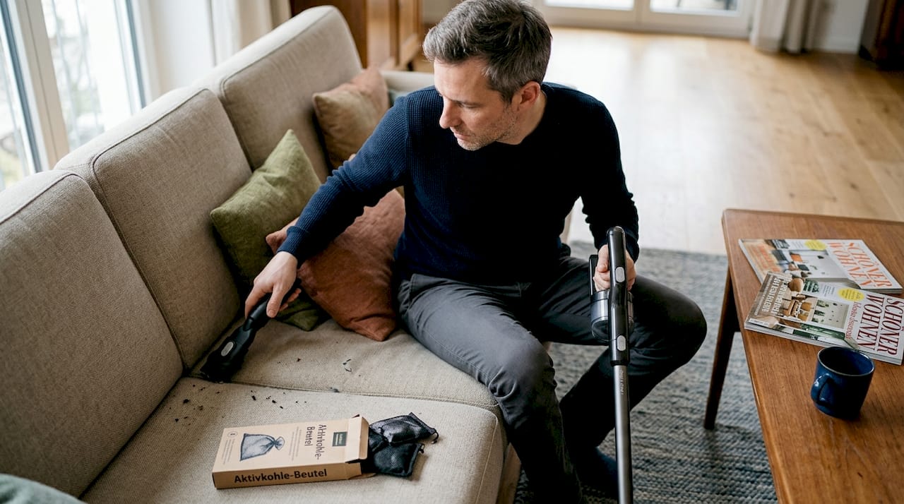 Um unangenehme Gerüche aus seinem Sofa zu entfernen, setzt ein Mann auf Aktivkohle.