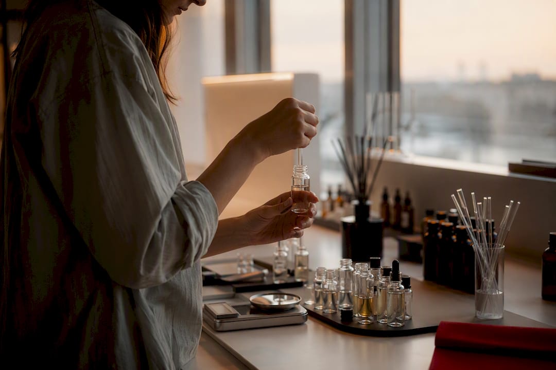 Ręce łączące olejki zapachowe w pracowni perfumiarza