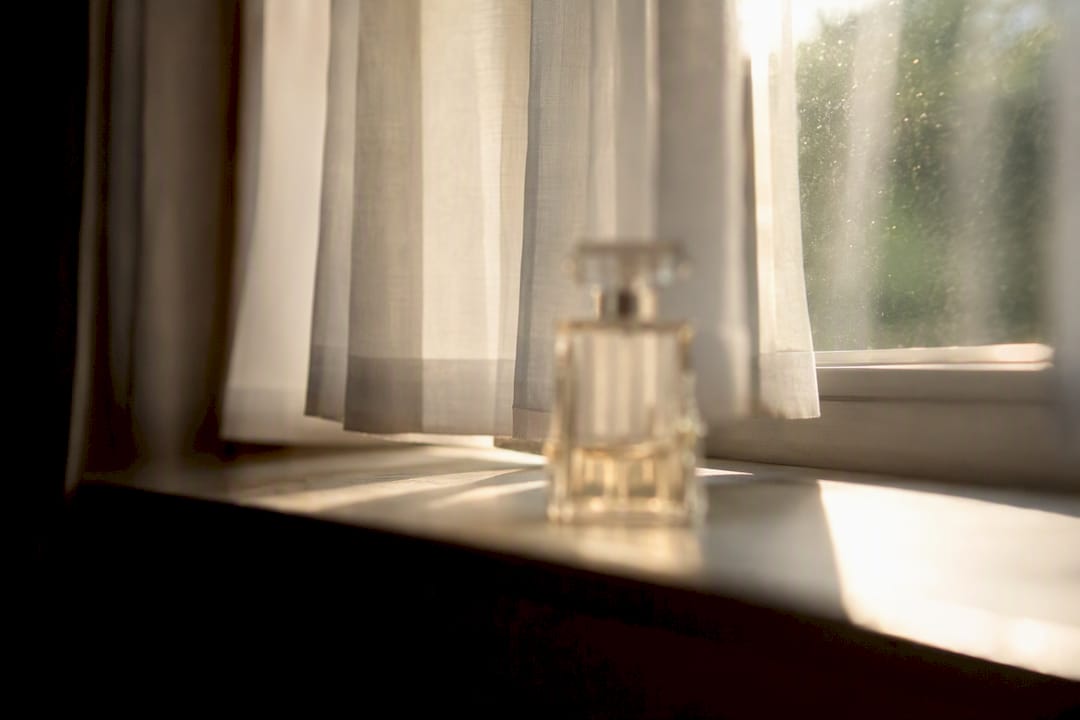 Zonlicht en warmte op een parfumflesje bij het raam