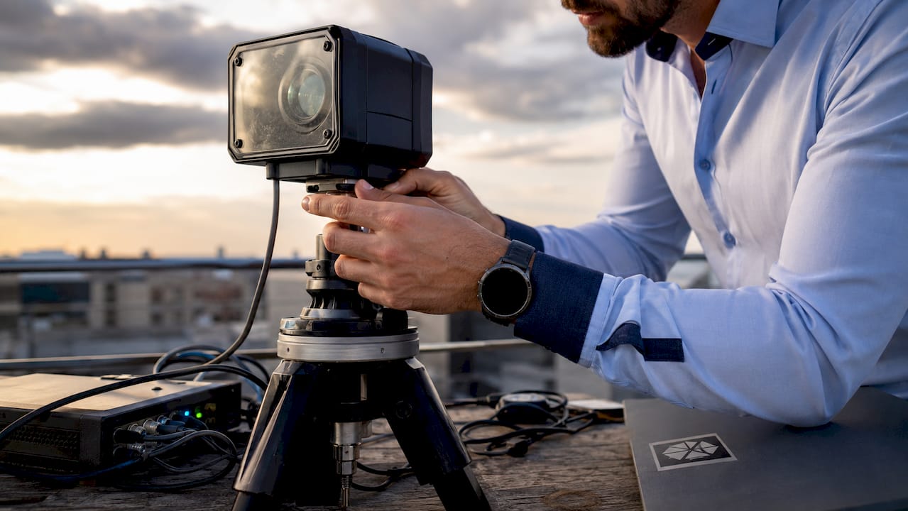 Tecnico al lavoro mentre sistema una telecamera per riprese in timelapse all’aperto