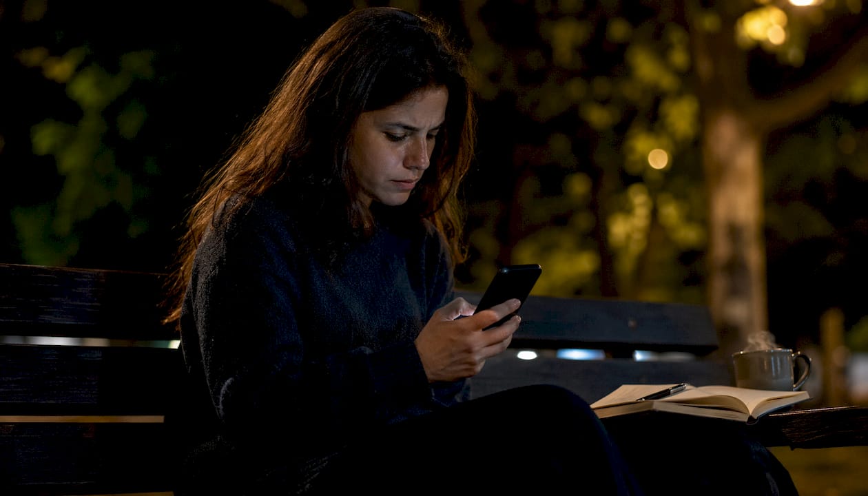 Una donna organizza un torneo all’aperto utilizzando un’app sul suo smartphone.