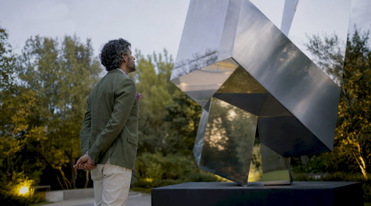 Viewer contemplating geometric abstract painting in gallery