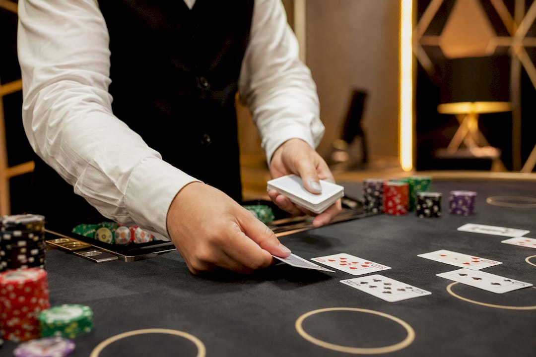 Manos del crupier repartiendo cartas en un casino en vivo