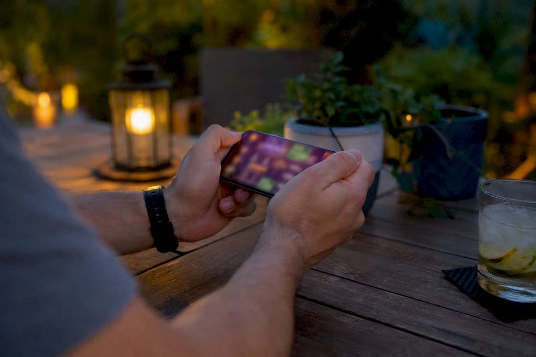 Manos sosteniendo un móvil con un juego de casino adaptativo