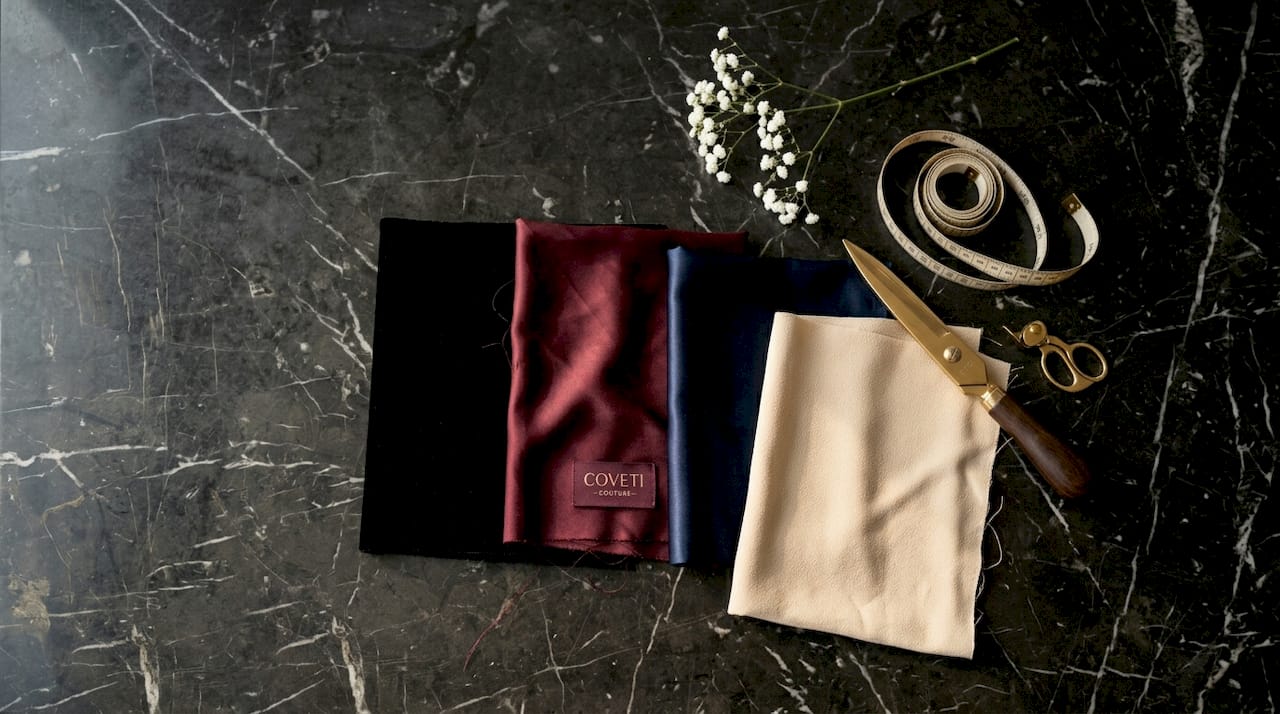 Muestras de telas lujosas en tonos elegantes dispuestas sobre la mesa.