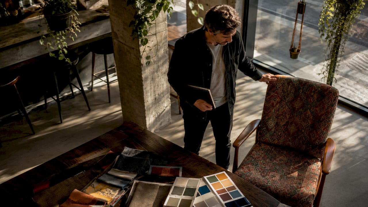 Un homme en quête du fauteuil parfait pour apporter une touche originale à son intérieur au style éclectique.