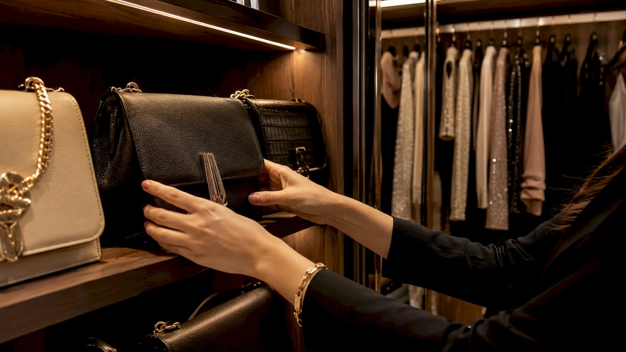 Colocando bolsos en un armario elegante